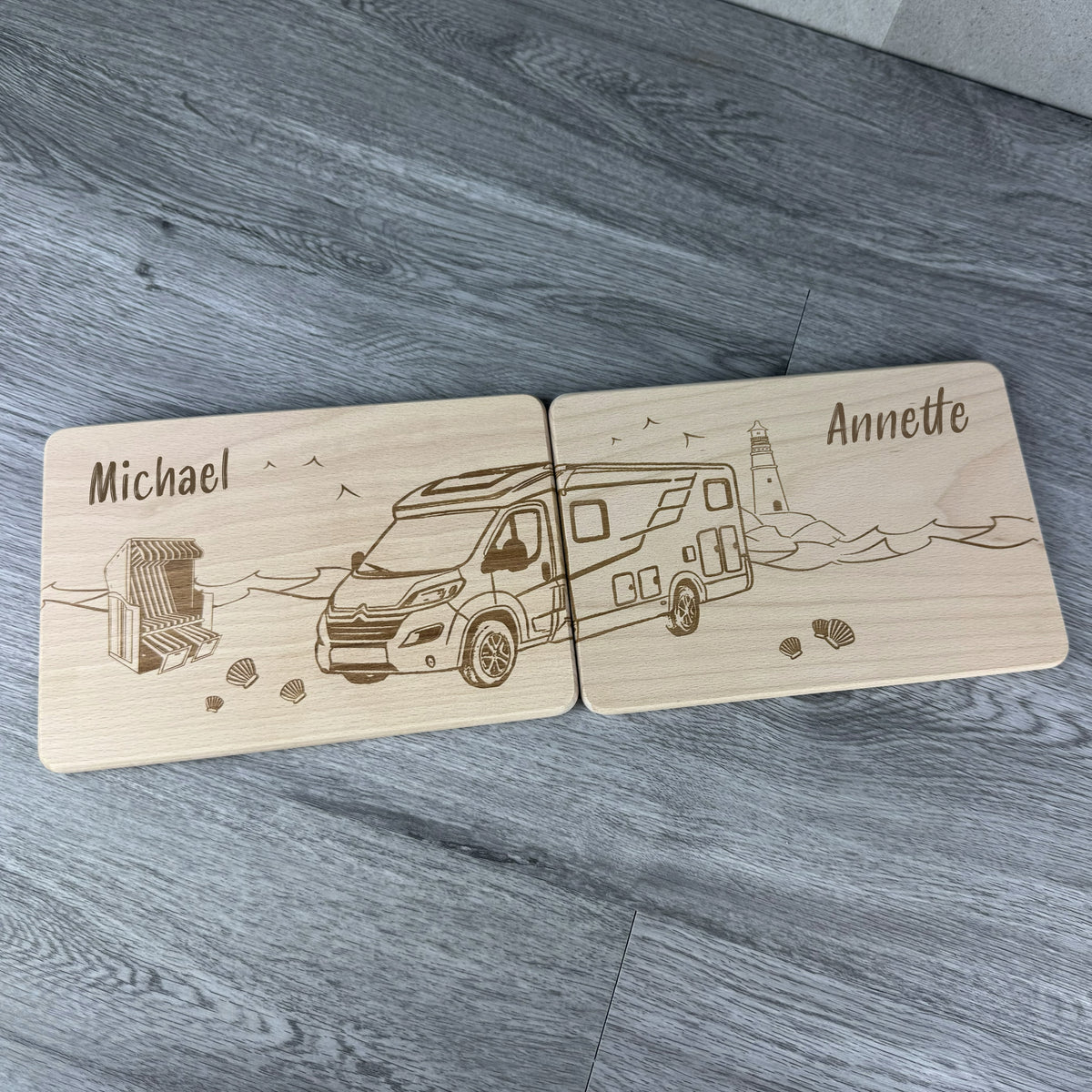 Graviertes Wohnmobil auf 2er Set Holzbrettchen als Geschenkidee für Paare, maritime Motive im Hintergrund