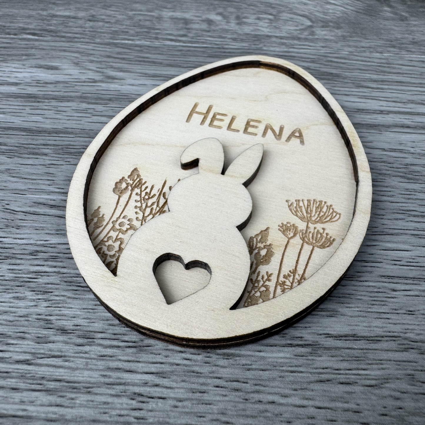 Seitenansicht Osteranhänger Hase auf Blumenwiese, mit Name personalisiert oder mit dem Text Frohe Ostern Gravur aus Holz, Lasergravur