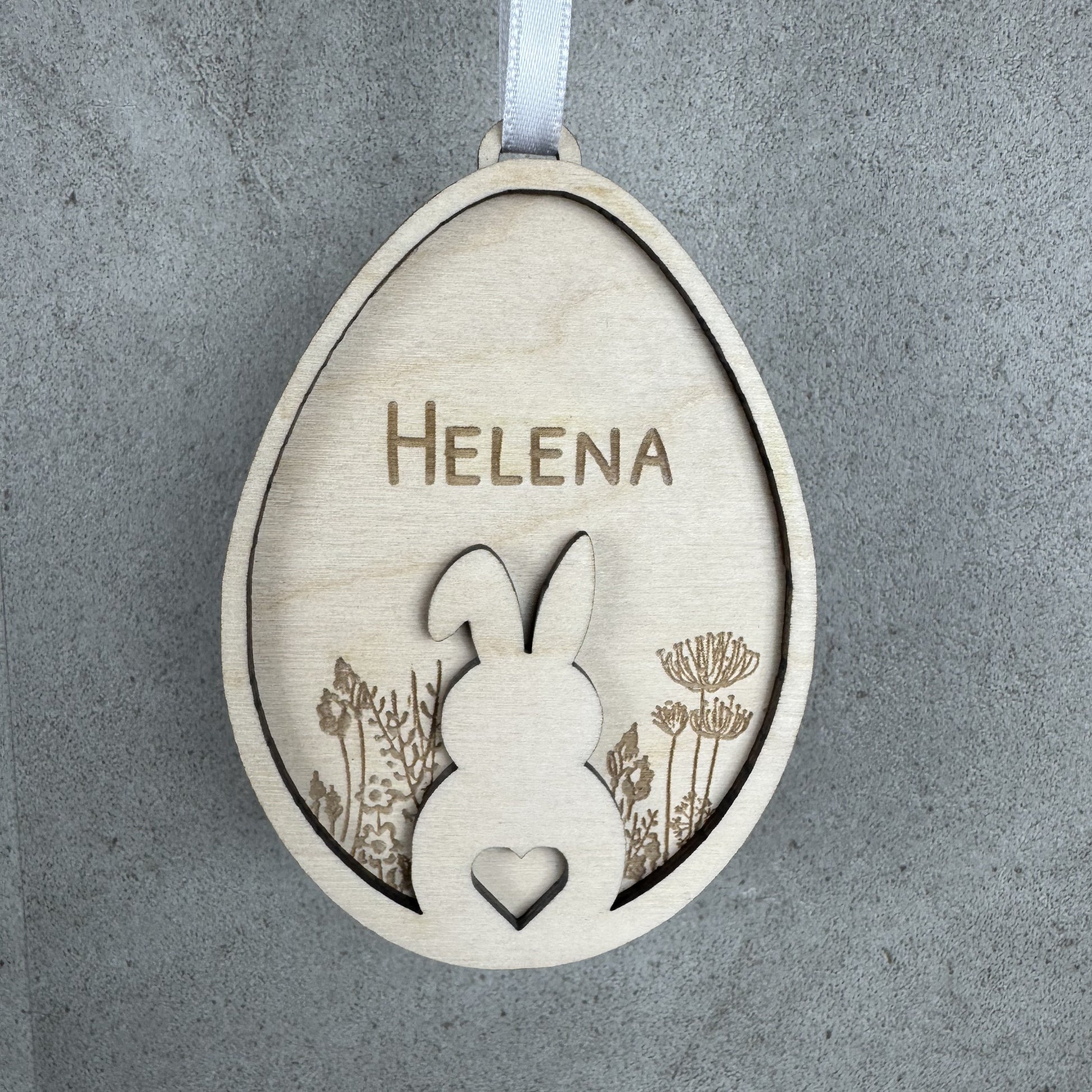 hängende Ansicht - Osteranhänger Hase auf Blumenwiese, mit Name personalisiert oder mit dem Text Frohe Ostern Gravur aus Holz, Lasergravur
