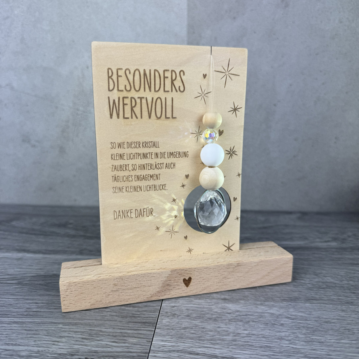 Holzkarte mit der Gravur „Besonders wertvoll“, funkelndem Kristall und filigranen Sternmotiven, optional mit passendem Kartenhalter aus Holz – besonderes Dankeschön-Geschenk für Erzieherinnen, Lehrerinnen und liebe Menschen.