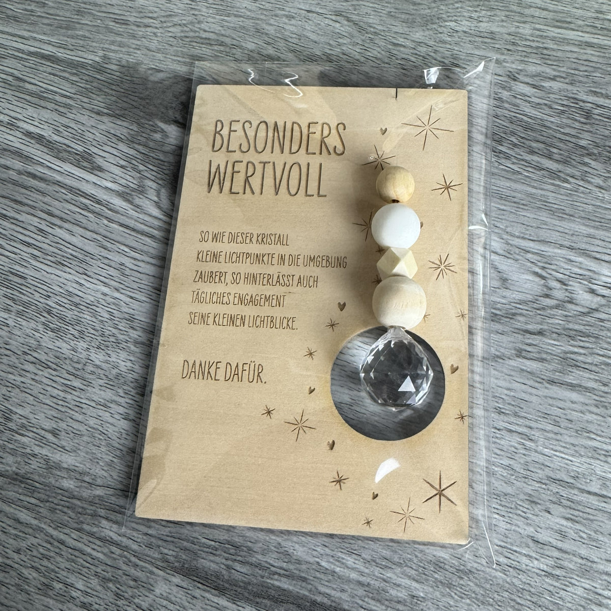 Holzkarte mit der Gravur „Besonders wertvoll“, funkelndem Kristall und filigranen Sternmotiven, optional mit passendem Kartenhalter aus Holz – besonderes Dankeschön-Geschenk für Erzieherinnen, Lehrerinnen und liebe Menschen.