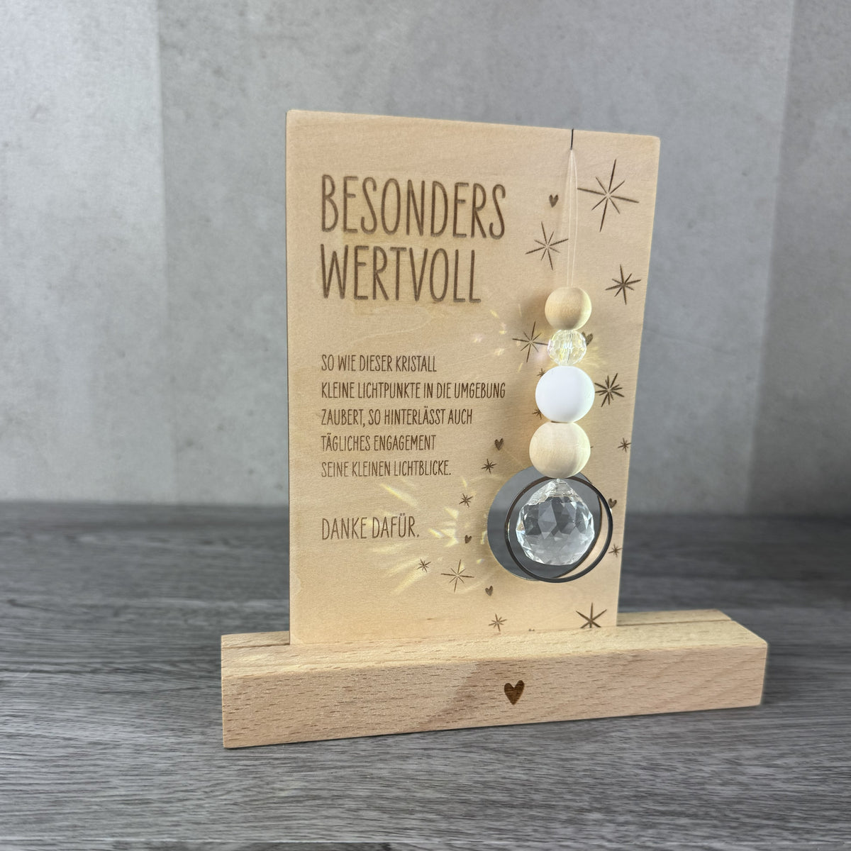 Holzkarte mit der Gravur „Besonders wertvoll“, funkelndem Kristall und filigranen Sternmotiven, optional mit passendem Kartenhalter aus Holz – besonderes Dankeschön-Geschenk für Erzieherinnen, Lehrerinnen und liebe Menschen.