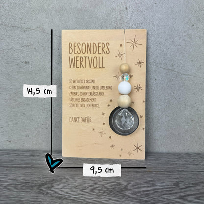 Größenangaben - 14,5 cm x 9,5 cm - Holzkarte mit der Gravur „Besonders wertvoll“, funkelndem Kristall und filigranen Sternmotiven, optional mit passendem Kartenhalter aus Holz – besonderes Dankeschön-Geschenk für Erzieherinnen, Lehrerinnen und liebe Menschen.