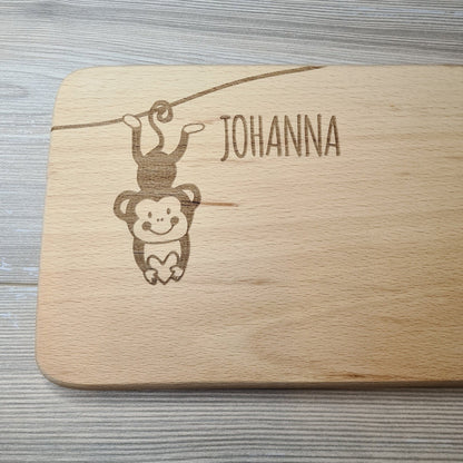 Beispiel Schriftart Brettchen mit Motiv und Name kleines Äffchen mit Herz in der Hand personalisiert dank individueller Gravur Affe Zootier Geschenkidee für Kinder zum Geburtstag Taufe Geburt Buchenbrett Holz verschiedene Schriftarten zur Auswahl